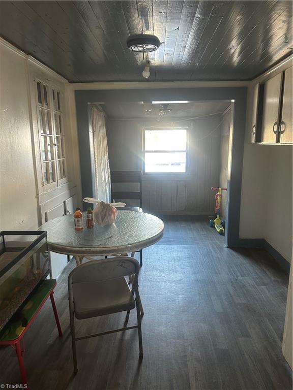 dining space featuring dark hardwood / wood-style floors and wood ceiling