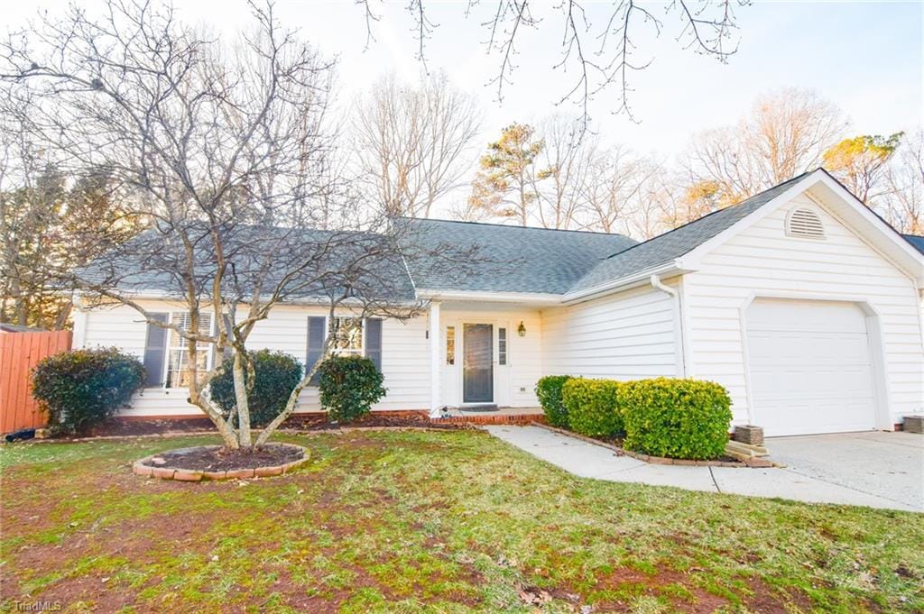 ranch-style house with a garage and a front lawn