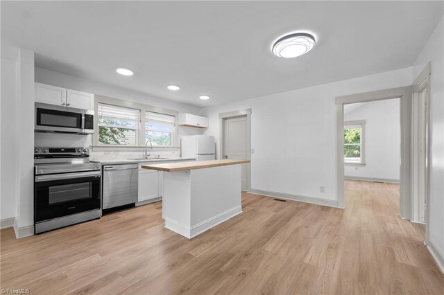 502 Eighth St, Mebane, NC 27302 - kitchen with appliances with stainless steel finishes, light countertops, white cabinets, a kitchen island, and recessed lighting
