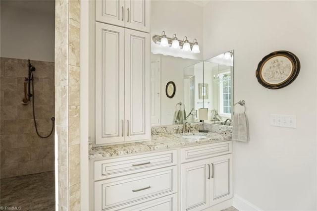 bathroom with vanity and a tile shower