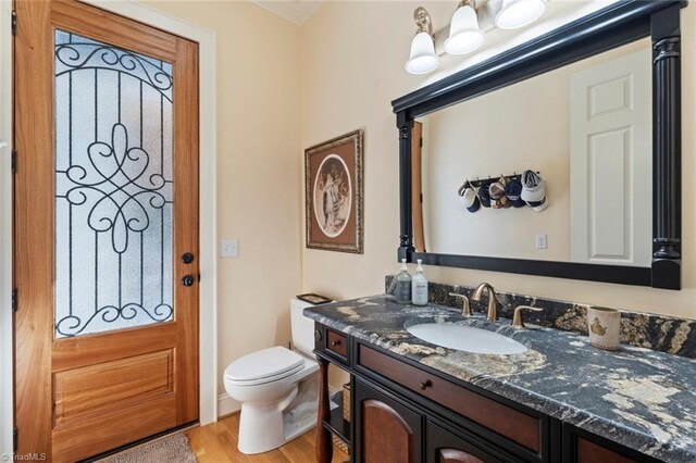 bathroom featuring toilet, hardwood / wood-style flooring, and vanity