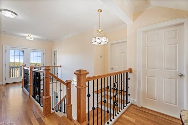 hall with ornamental molding, french doors, and wood-type flooring