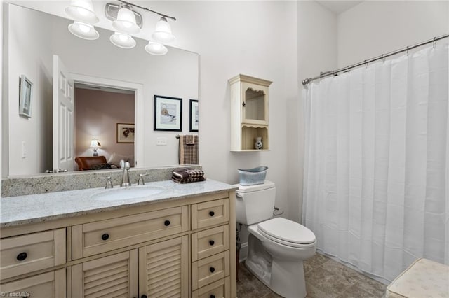 bathroom featuring toilet, walk in shower, vanity, and tile patterned floors