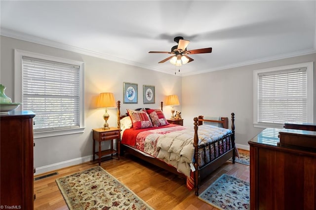 bedroom with multiple windows, ornamental molding, hardwood / wood-style flooring, and ceiling fan