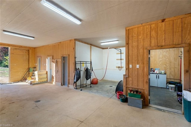 miscellaneous room featuring wooden walls and concrete flooring