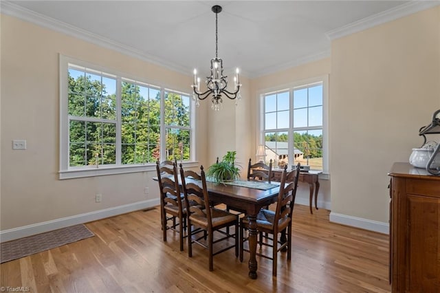 dining space featuring an inviting chandelier, light hardwood / wood-style flooring, and crown molding