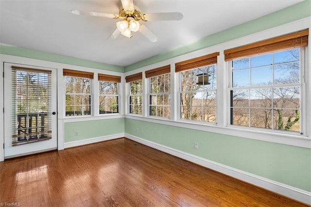 unfurnished sunroom featuring a ceiling fan and a healthy amount of sunlight