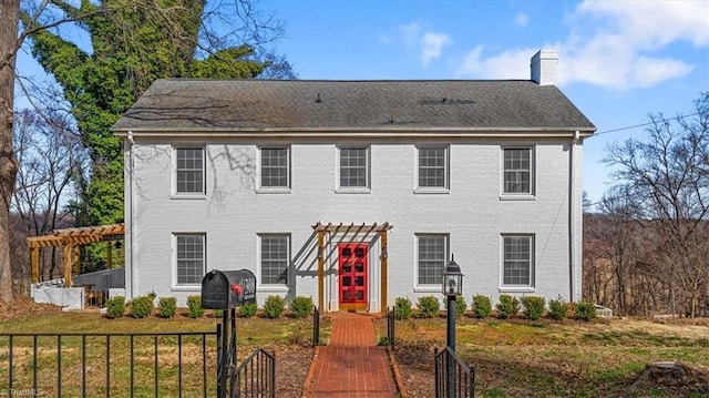 colonial home with a chimney, a pergola, brick siding, and fence