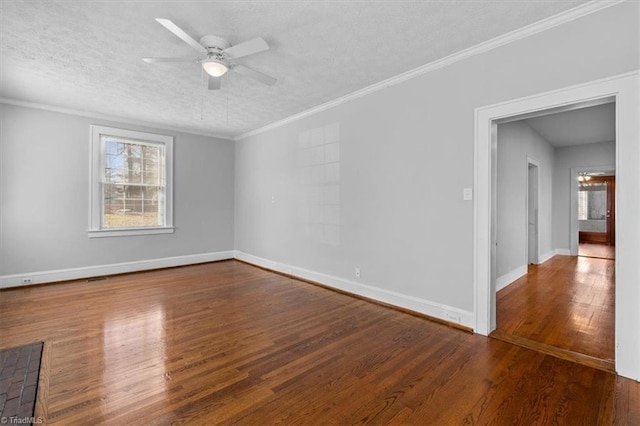 empty room with ornamental molding, a textured ceiling, wood finished floors, baseboards, and ceiling fan