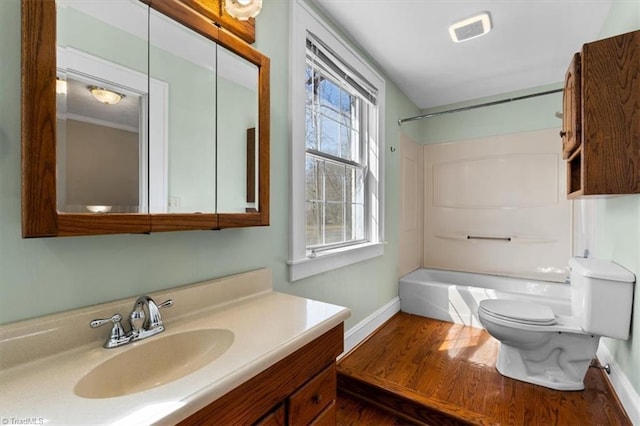 bathroom featuring toilet, wood finished floors,  shower combination, baseboards, and vanity