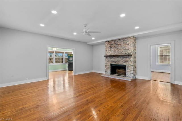 unfurnished living room with recessed lighting, wood finished floors, and a fireplace