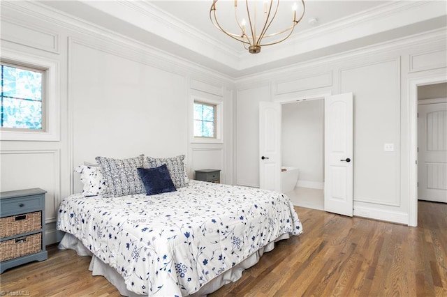 bedroom featuring dark hardwood / wood-style flooring, ornamental molding, and a chandelier