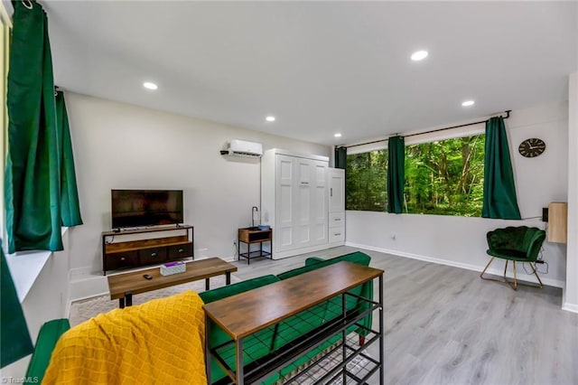 interior space featuring recessed lighting, wood finished floors, baseboards, and a wall mounted air conditioner