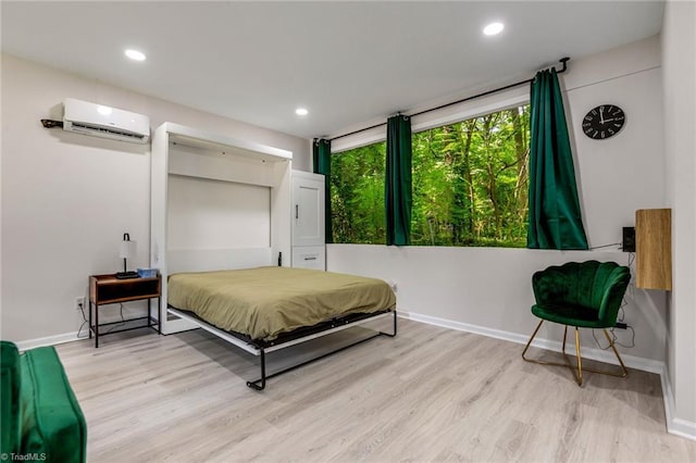 bedroom with recessed lighting, baseboards, an AC wall unit, and wood finished floors