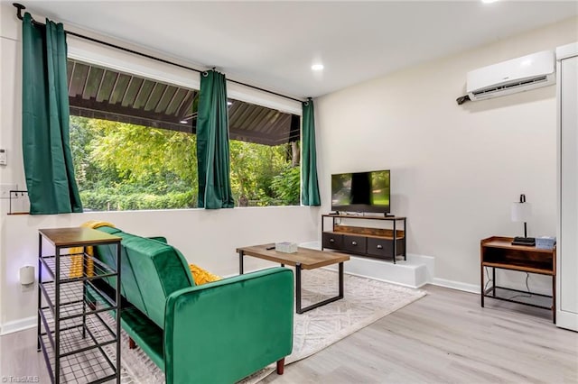 living room with wood finished floors, baseboards, and a wall mounted AC