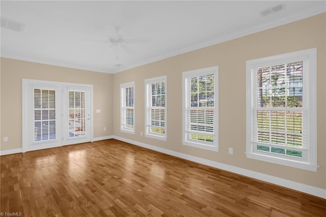 empty room featuring ceiling fan, ornamental molding, and hardwood / wood-style floors