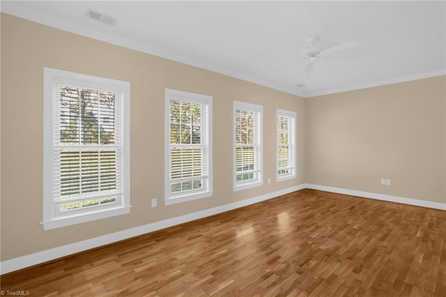 unfurnished room with hardwood / wood-style floors, ornamental molding, a healthy amount of sunlight, and ceiling fan