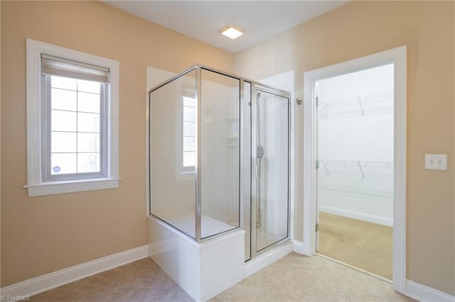 bathroom with an enclosed shower and tile patterned flooring