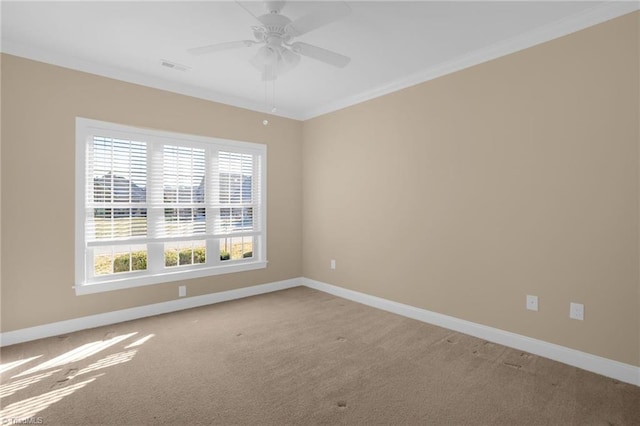 empty room featuring carpet floors, ornamental molding, and ceiling fan