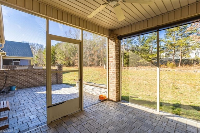 unfurnished sunroom featuring ceiling fan