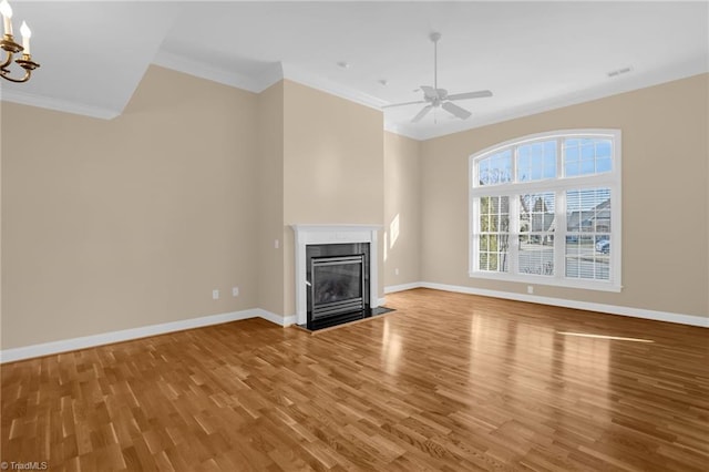 unfurnished living room featuring hardwood / wood-style flooring, ornamental molding, and ceiling fan with notable chandelier