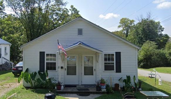 bungalow-style home featuring a front lawn