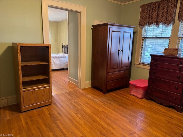 unfurnished bedroom with ornamental molding and light wood-type flooring