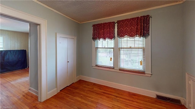 1610 S Main St, Mount Airy, NC 27030 - unfurnished bedroom with wood finished floors, multiple windows, crown molding, baseboards, and a textured ceiling