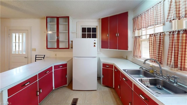 1610 S Main St, Mount Airy, NC 27030 - kitchen featuring red cabinetry, freestanding refrigerator, a sink, healthy amount of natural light, and a textured ceiling