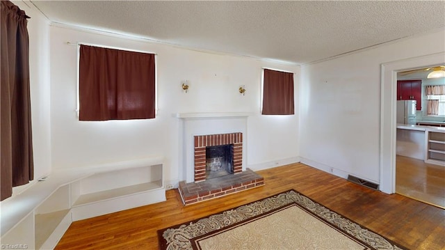 1610 S Main St, Mount Airy, NC 27030 - unfurnished living room with wood finished floors, a textured ceiling, a fireplace, and baseboards