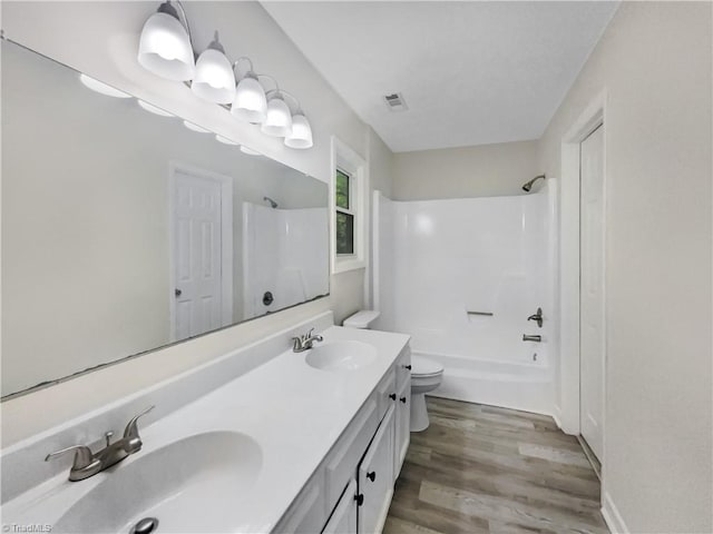 full bathroom with vanity, toilet, hardwood / wood-style floors, and shower / bathtub combination