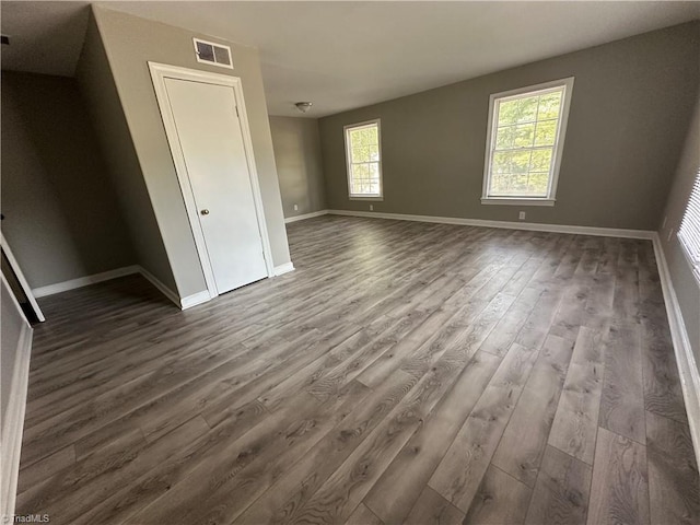 empty room featuring a healthy amount of sunlight and hardwood / wood-style floors