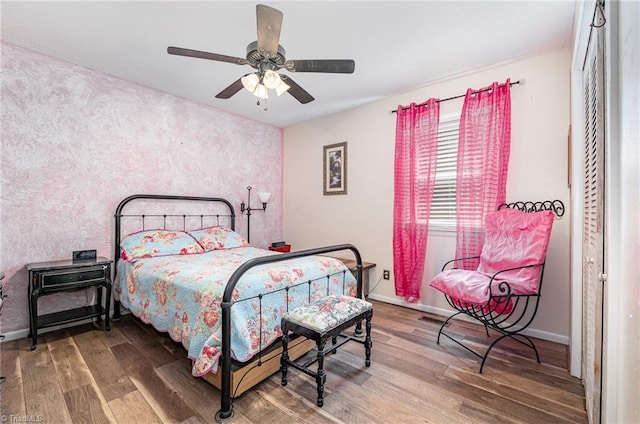 6517 Benson Ln, Pfafftown, NC 27040 - bedroom featuring wood finished floors, a ceiling fan, and an accent wall