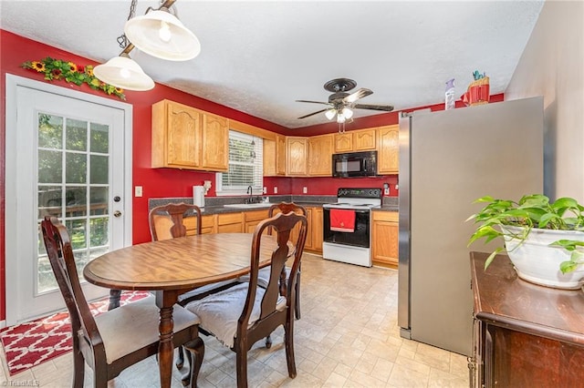 6517 Benson Ln, Pfafftown, NC 27040 - kitchen featuring white electric range, black microwave, freestanding refrigerator, and healthy amount of natural light