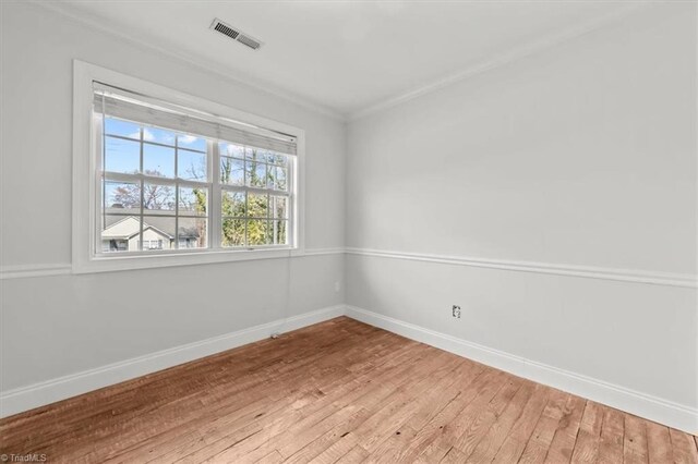 3523 Riverside Dr, Greensboro, NC 27406 - spare room featuring light wood finished floors, baseboards, visible vents, and crown molding