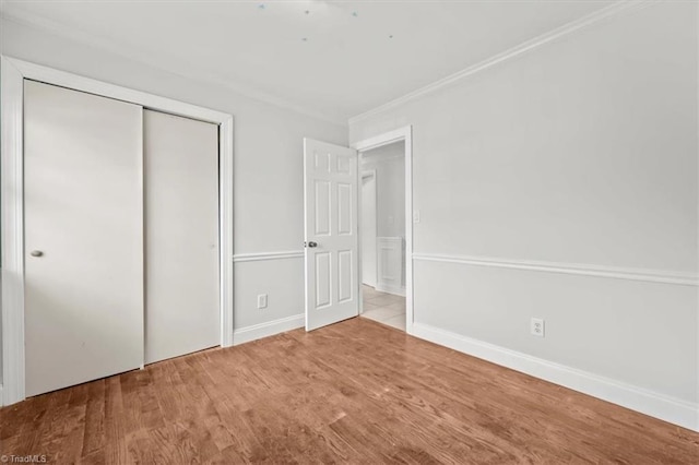 3523 Riverside Dr, Greensboro, NC 27406 - unfurnished bedroom with baseboards, a closet, crown molding, and wood finished floors