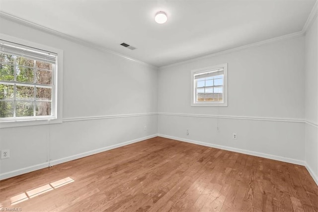 3523 Riverside Dr, Greensboro, NC 27406 - spare room with baseboards, visible vents, wood finished floors, and ornamental molding