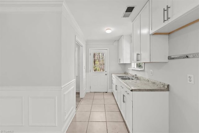3523 Riverside Dr, Greensboro, NC 27406 - kitchen with visible vents, white cabinets, a sink, and light tile patterned floors