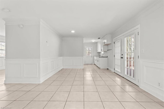 3523 Riverside Dr, Greensboro, NC 27406 - interior space featuring a wainscoted wall, a decorative wall, crown molding, and light tile patterned floors