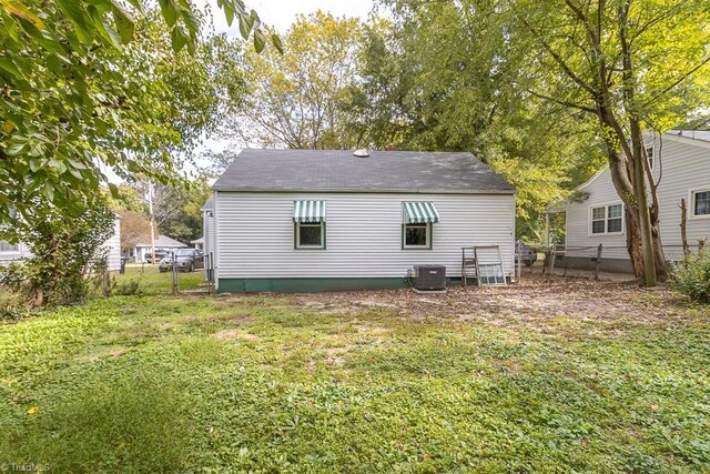 rear view of house featuring a yard and central air condition unit