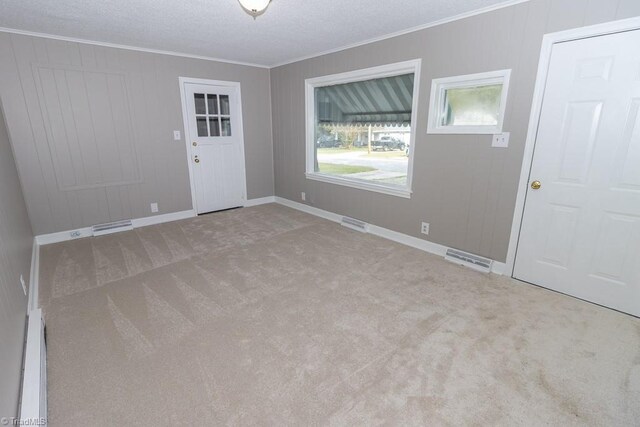 entrance foyer featuring light carpet, a baseboard heating unit, crown molding, and a textured ceiling