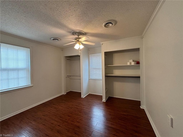 unfurnished bedroom featuring a textured ceiling, ornamental molding, dark wood-type flooring, and ceiling fan