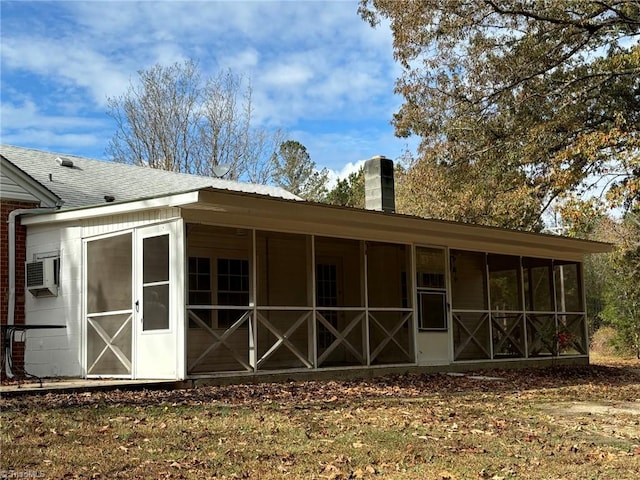 rear view of house featuring a sunroom