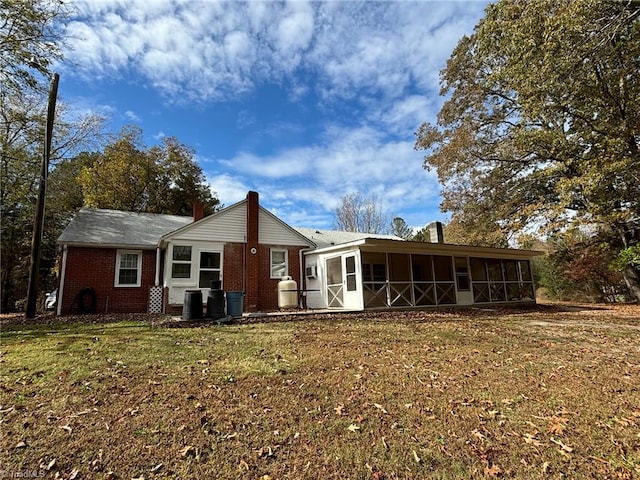 back of property featuring a sunroom and a yard