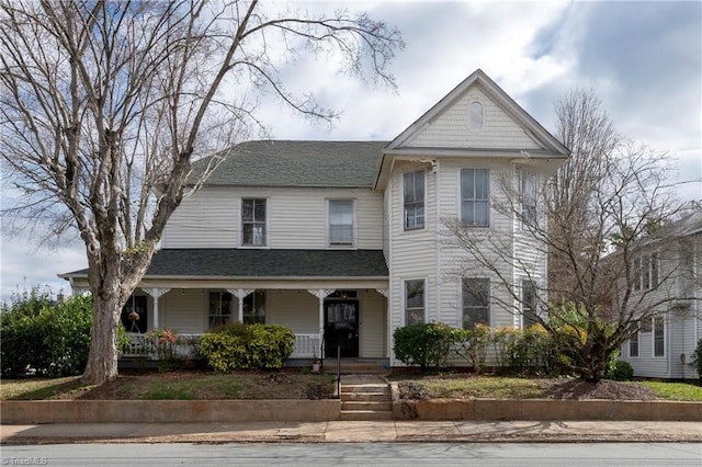 victorian home featuring covered porch and a shingled roof