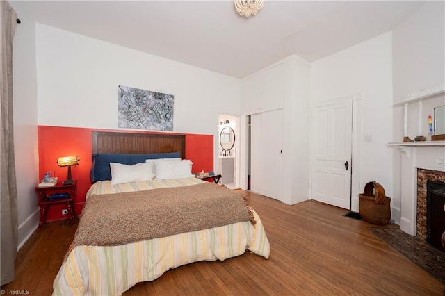 bedroom featuring a fireplace and wood finished floors