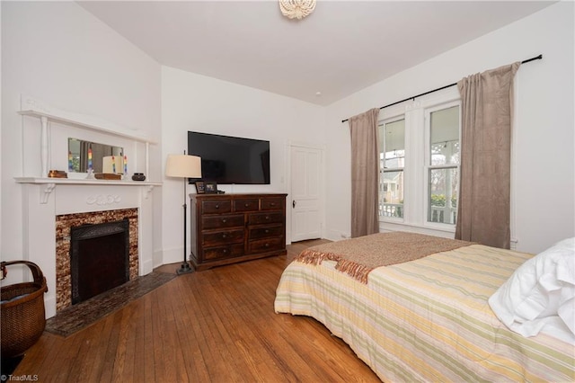 bedroom with a premium fireplace and wood-type flooring