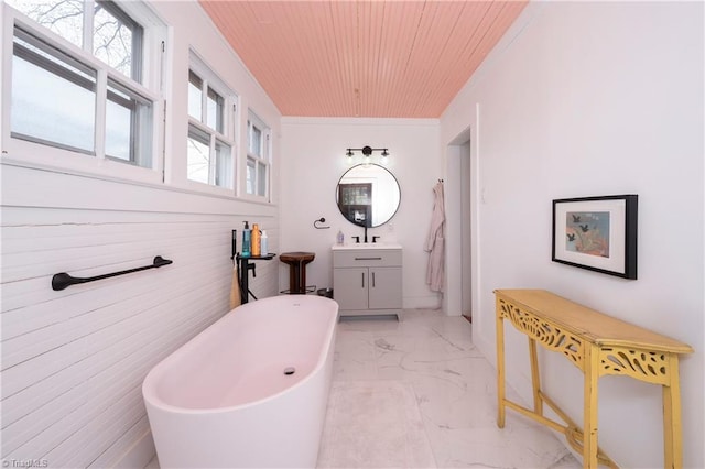 full bathroom with marble finish floor, ornamental molding, a freestanding tub, vanity, and wooden ceiling