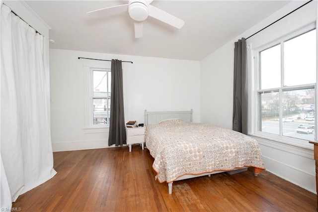 bedroom with hardwood / wood-style flooring, baseboards, and a ceiling fan