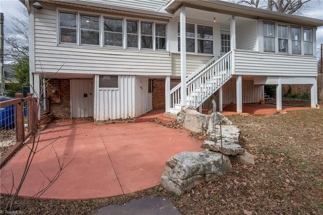 back of house with a patio, brick siding, and stairway